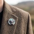 Highland cow paua shell pin badge on a tweed jacket