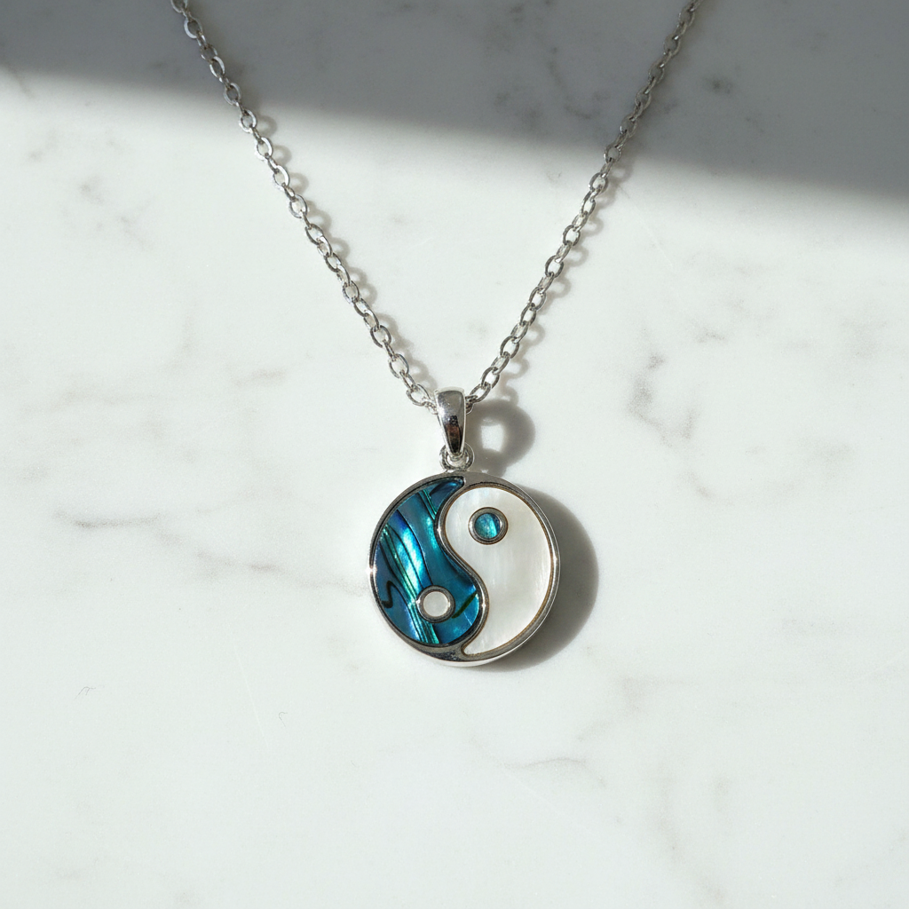 Yin yang necklace close-up on white marble surface