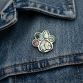 Paua shell paw print pin badge on denim jacket lapel