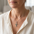 Woman wearing a delicate Paua shell cross necklace